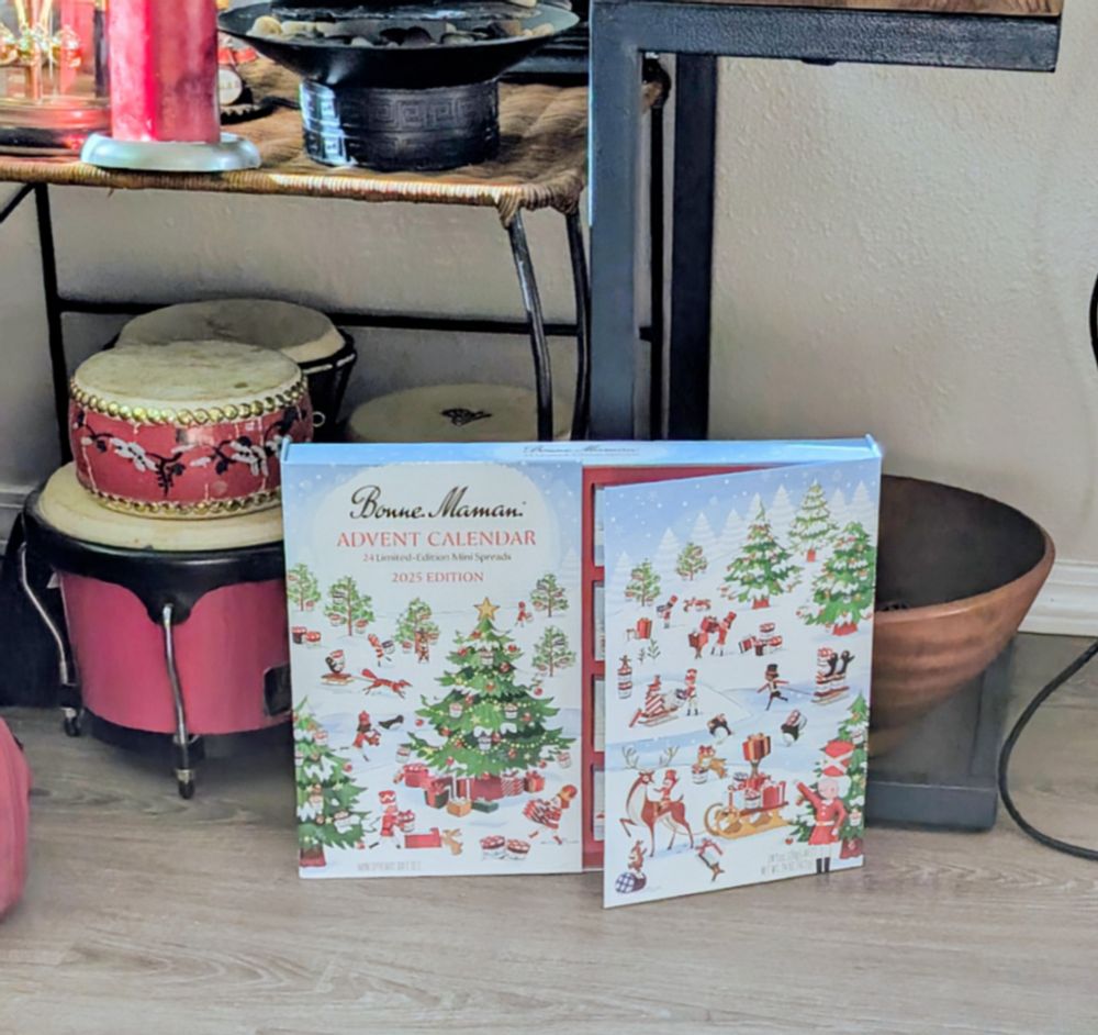 Advent calendar box shown on living room floor next to drum collection. 