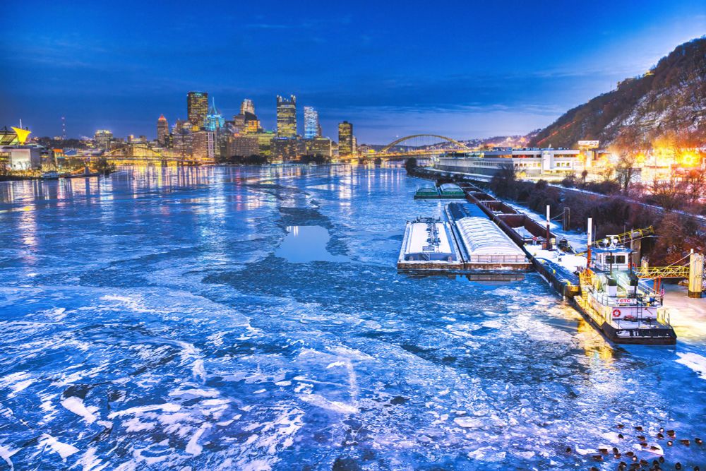 A photograph of Pittsburgh from the west end bridge. The river is frozen. 