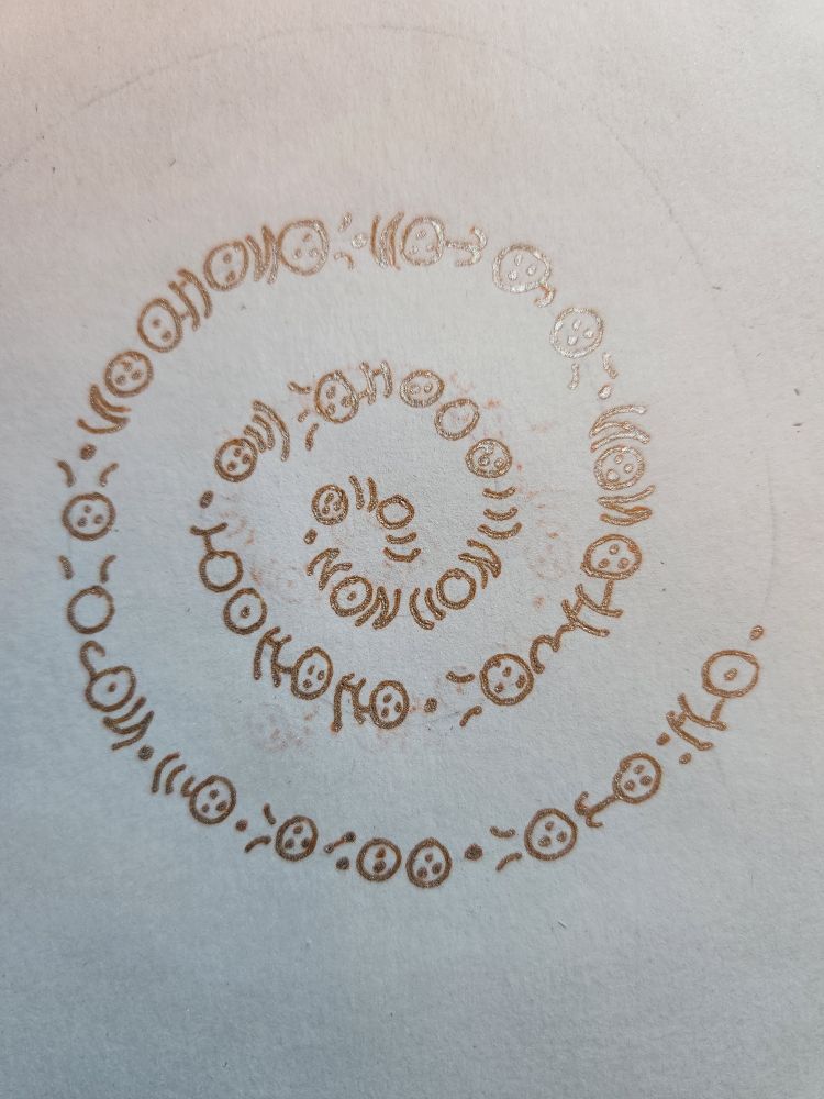 Fairy alphabet of circles, curves, and dots, in an orange silver-shadow ink, reading "babi membamwilaulidwi 'aeriri tivrinin tipikin tinuluin titapen wi tibvui tikipfre"