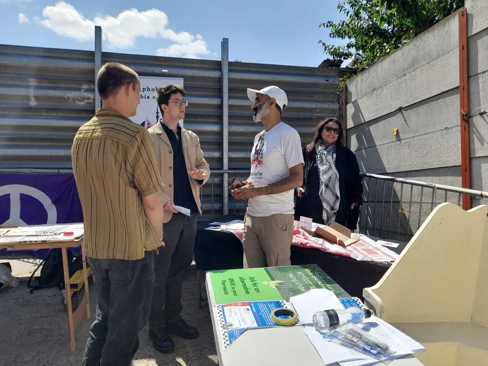A photo of Matt talking to stallholders at the We Demand Change summit.