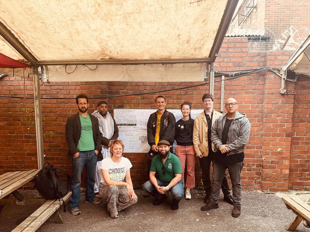 A group photo of Matt and other Greens in front of a whiteboard, titled "What future actions do you want to see?"