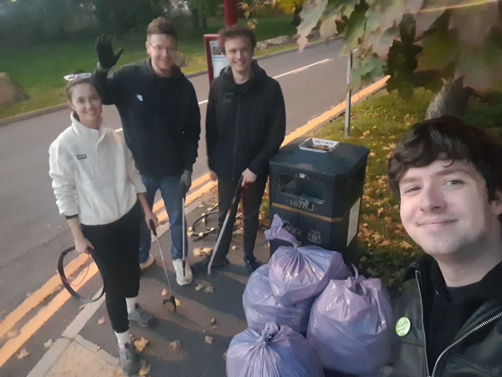 A selfie of Matt and the Green team with four purple bags of litter