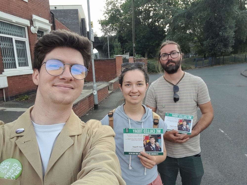 A selfie of Matt, along with Green team members Cristiana and James. They are holding calling cards for Matt.