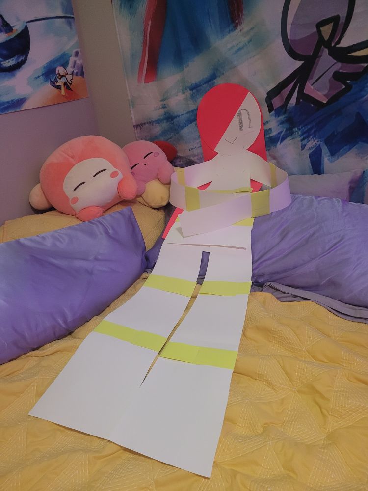 a lifesized cardstock replica of a lamina, sitting on a bed