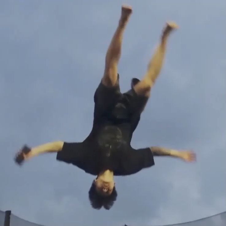jungkook upside down holding his phone flying thru the air 