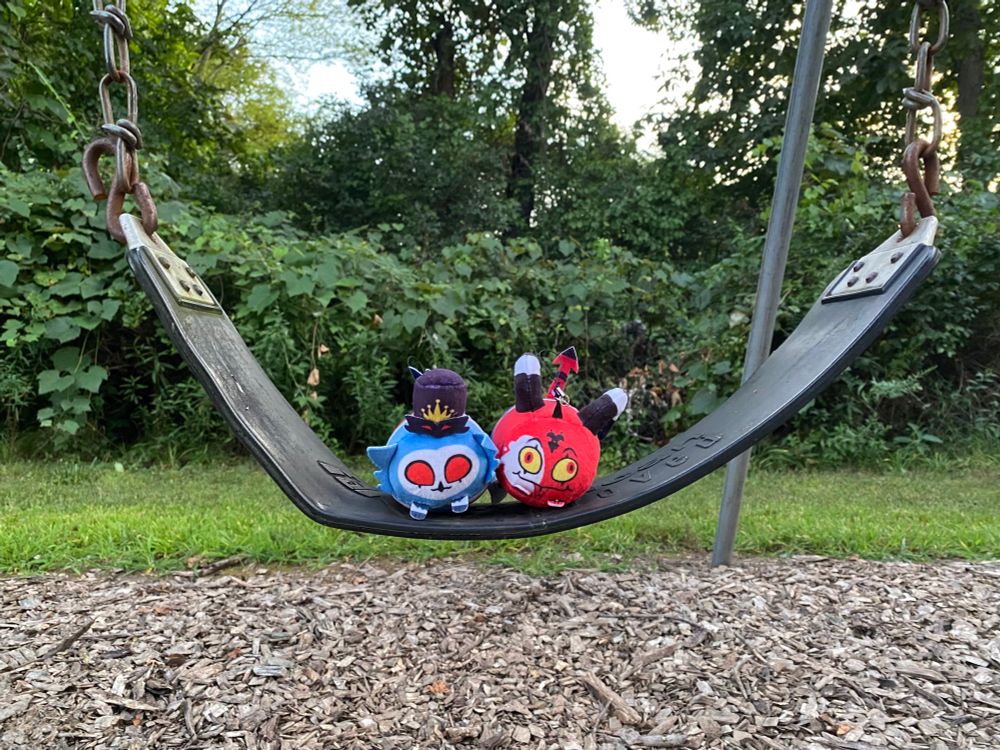 Photo of my Stolitz nugget plushies sitting on a swing outside