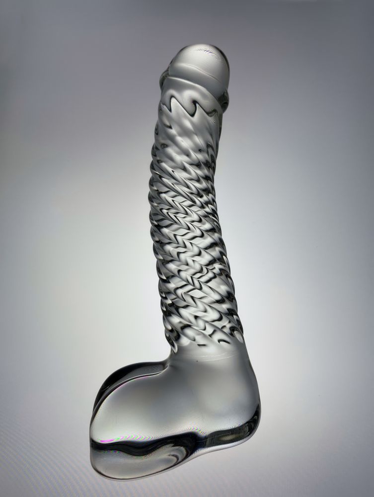 Black and white image of a glass phallic dildo lighted from the side.