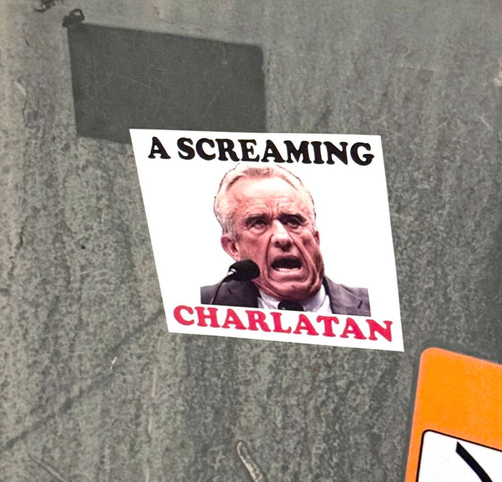 A sticker on submittal box has RFK Junior with his mouth open yelling, and it reads: A SCREAMING CHARLATAN