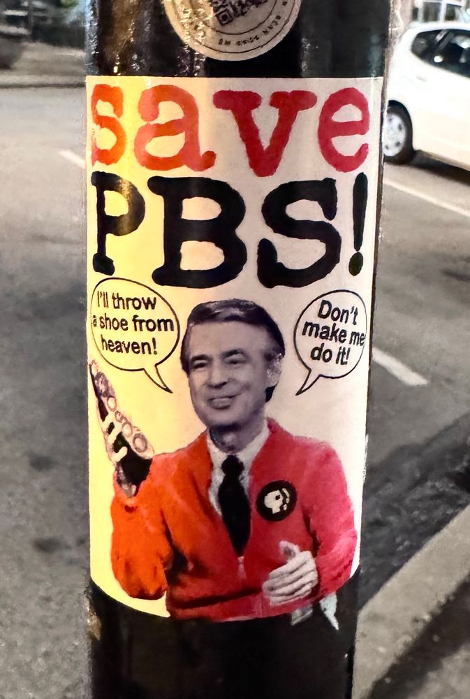 A sticker on a pole has a picture of Mr Roger’s and reads: SAVE PBS!
