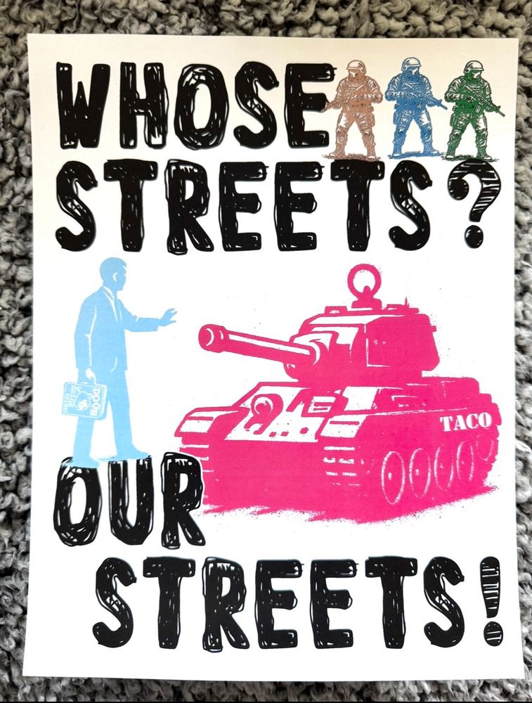 Poster has a pink tank with a blue man holding a briefcase standing up, holding his hand out to stop the tank it reads: WHOSE STREETS? OUR STREETS!