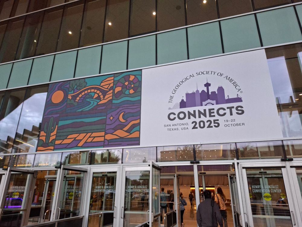 A billboard on the side of a large building advertising the Geological Society of America Connects 2025 conference. 
