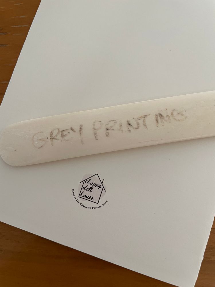 A bone tool on the back cover of Colossal, showing the Chappy Doll House logo