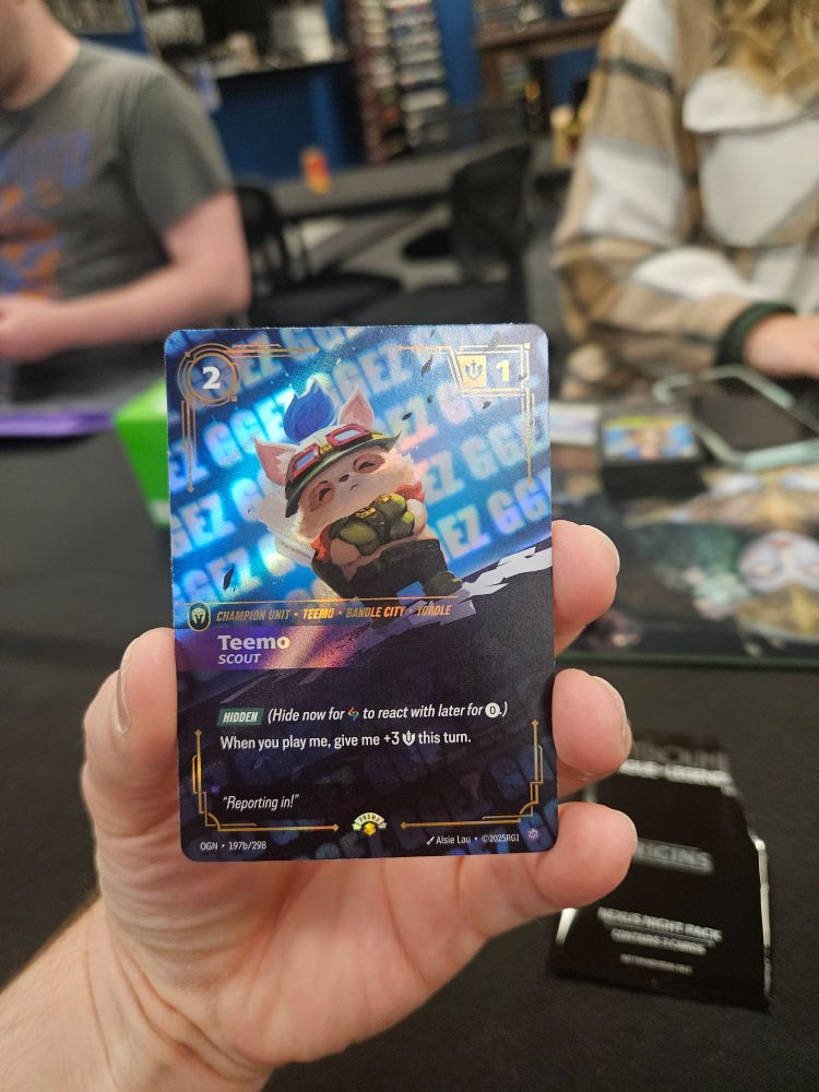 A Teemo card for the TCG Riftbound. In the card's art, Teemo looks to be standing on a stage or such with "GGEZ" repeated all over the background.