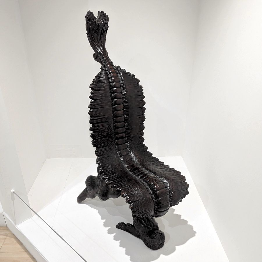 Photo of a black chair that looks disturbingly curvy, organic, and spinal. 