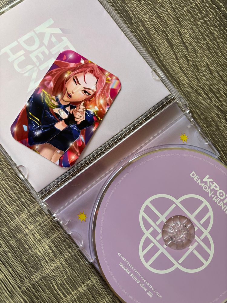 The lilac CD and interior CD jewel case for the kpop demon hunters album along with a Mira photocard