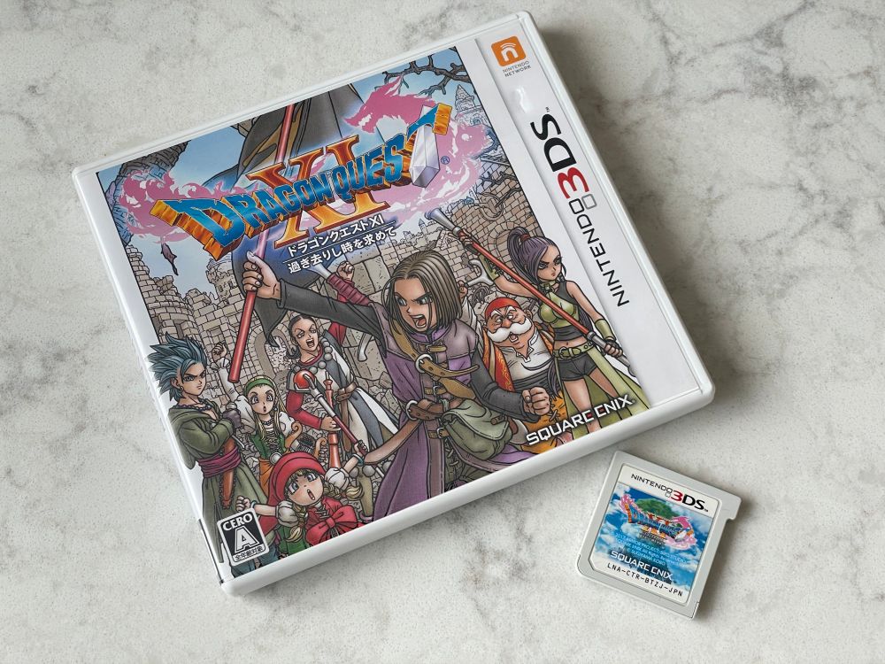 Dragon Quest XI for the Nintendo 3DS, picturing the case and cartridge lying on a stone countertop. This was only released in Japan.