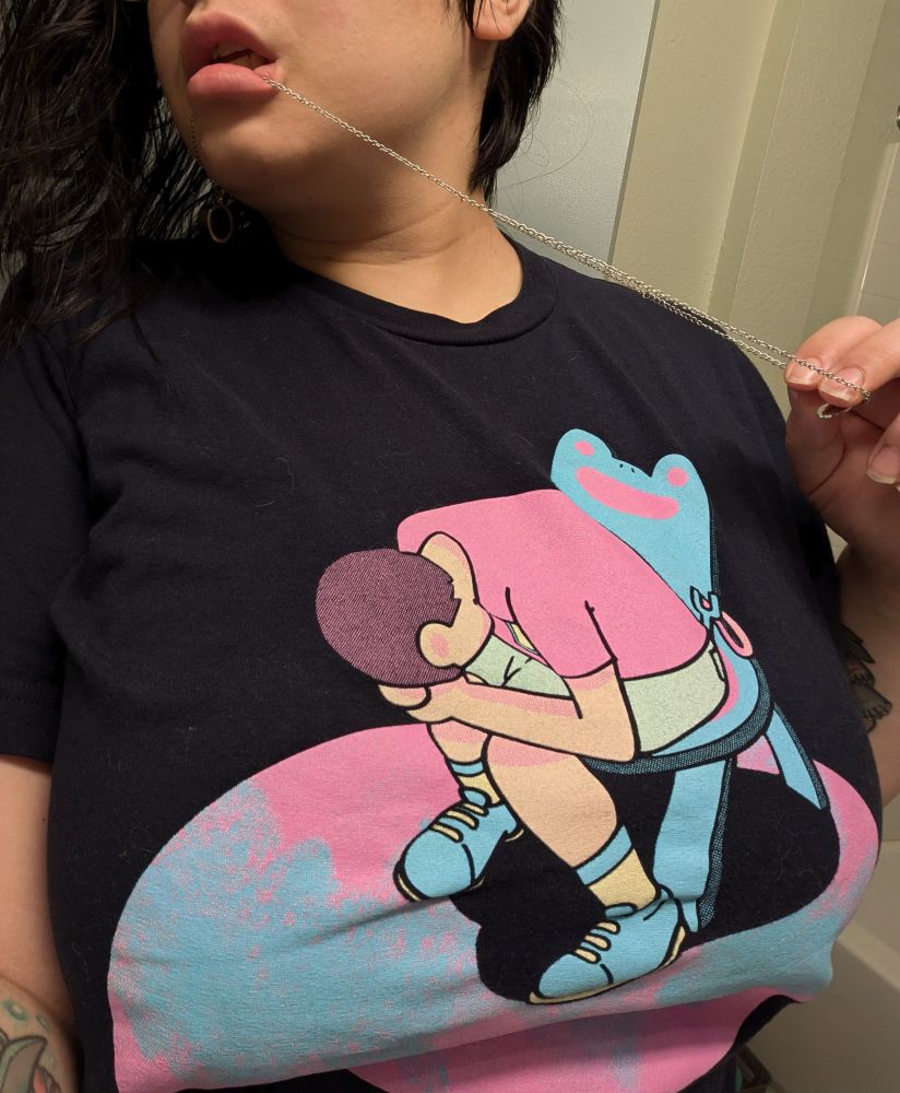 A necklace chain pulled through plump lips. Stretched over big tits is a black T-shirt with an image of the villager from animal crossing sitting in a froggy chair and crying like shinji from end of evangelion.