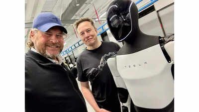 Salesforce CEO Benioff, Elon Musk standing next to an Optimus robot looking pleased 