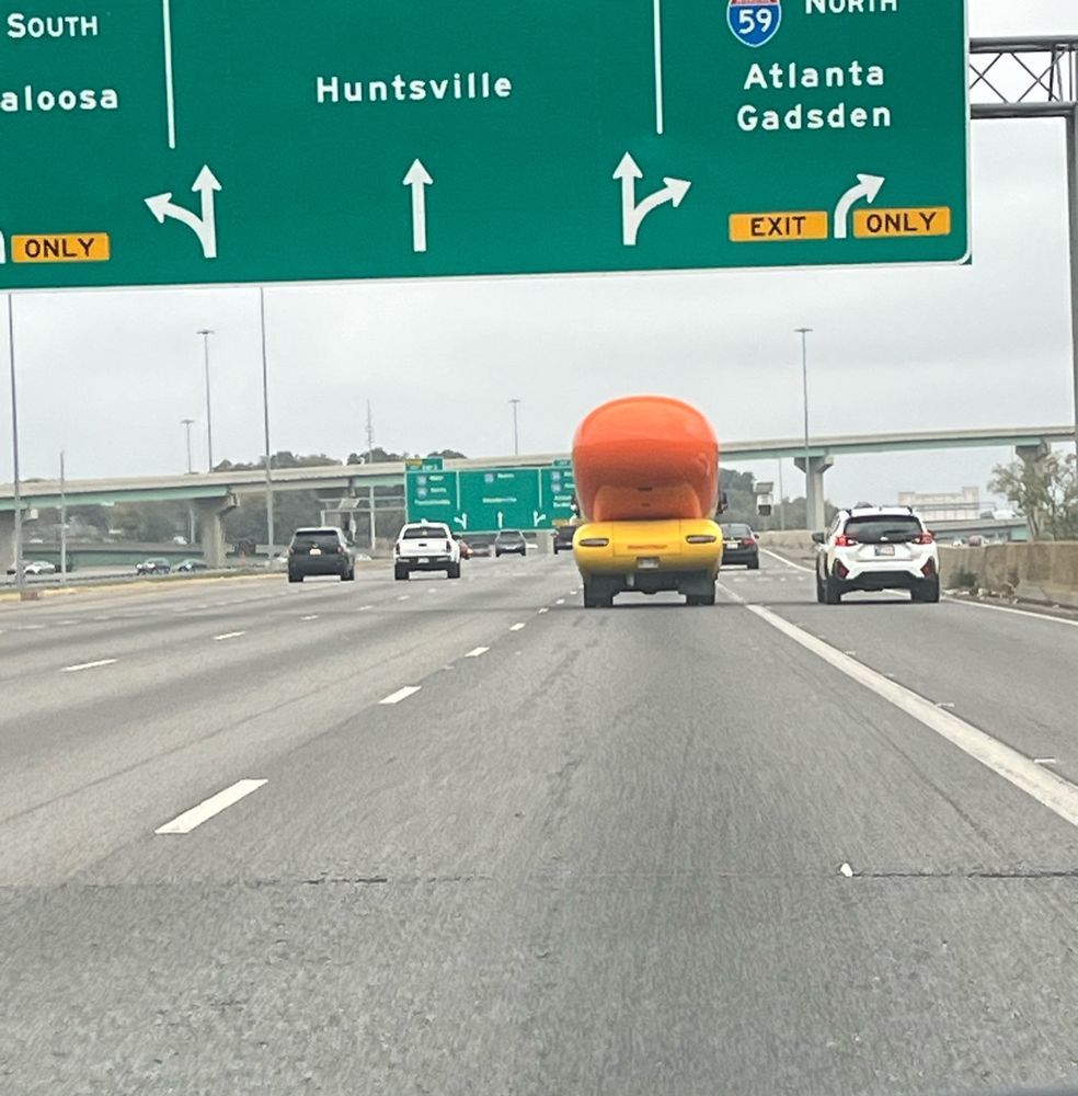 A picture of an Oscar Meyer wiener mobile (small) from behind as it drives down I-65 North 