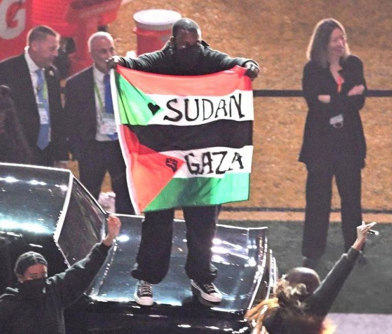 A background dancer during Kendrick Lamar's Super Bowl halftime show holds up a Sudanese and Palestinian combination flag during the performance.
