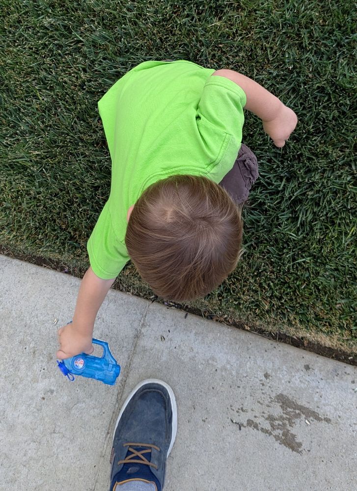 Grandson is mastering the art of squirting grandpa. 