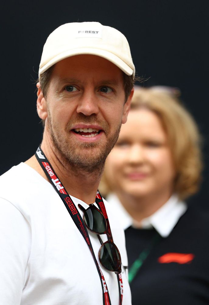close up photo of sebastian vettel. he's wearing a white hat and shirt with the f1orest logo, his initiative for this year in brazil 