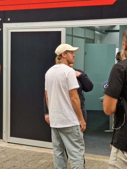 photo from behind seb as he's taking photos/speaking to people in the paddock