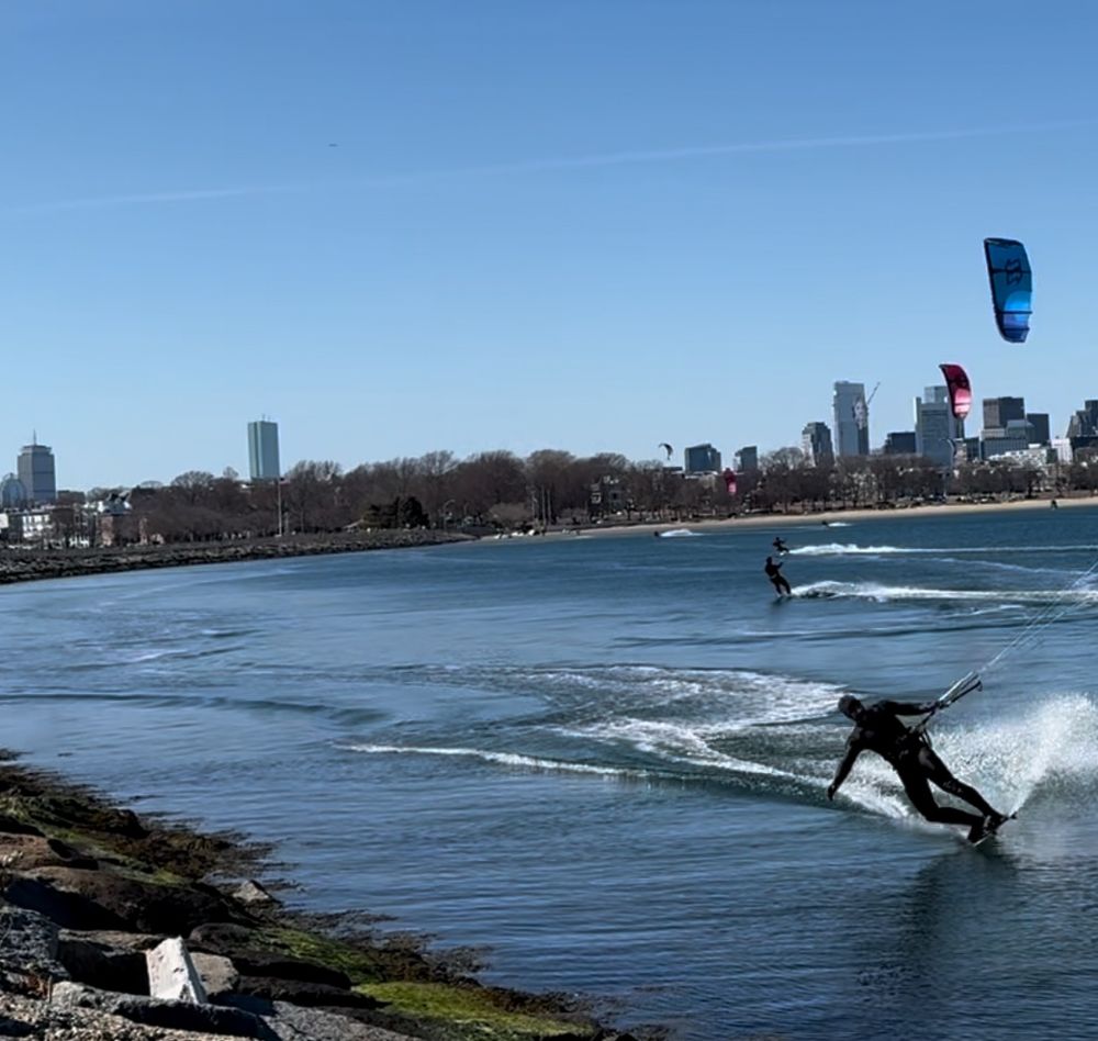 Kite surfers in front of Boston skyline 