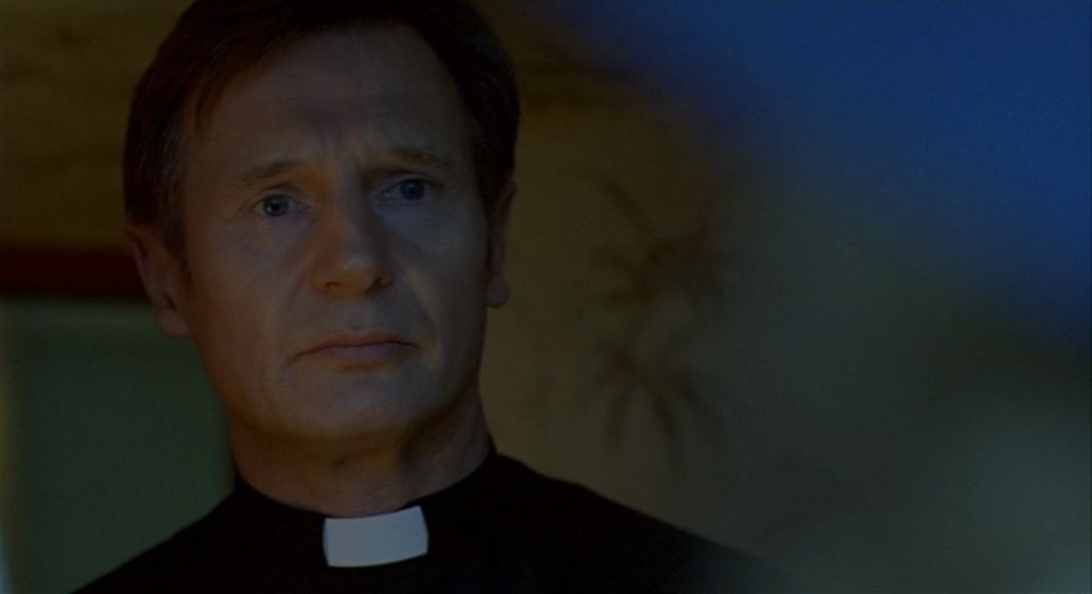 Liam Neeson as Father Liam in the film Breakfast at Pluto.