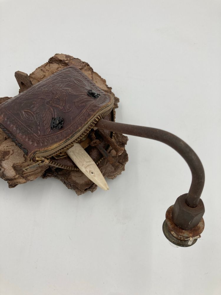 Assemblage of a vintage leather coin purse, metal snaps, found metal scraps, a bone fish and a lightbulb mounted on sycamore bark.

#assemblage #art #sculpture
