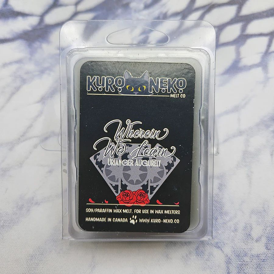 A set of wax melts in a clamshell on a blue and white tie dye background. The pictured scent is Wherein We Learn: Urianger Augerelt.