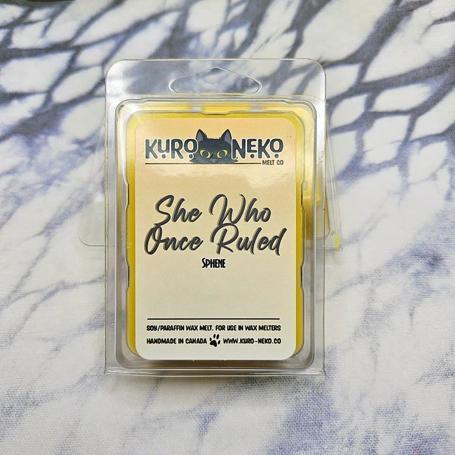 A set of wax melts in a clamshell on a blue and white tie dye background. The pictured scent is She Who Once Ruled: Sphene.

Scent notes of lime, pineapple, black currant leaves, jasmine, rose, orange blossom, and musk.