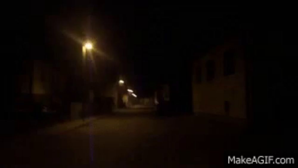 a blurred image of a street at night with the website makeagif.com visible