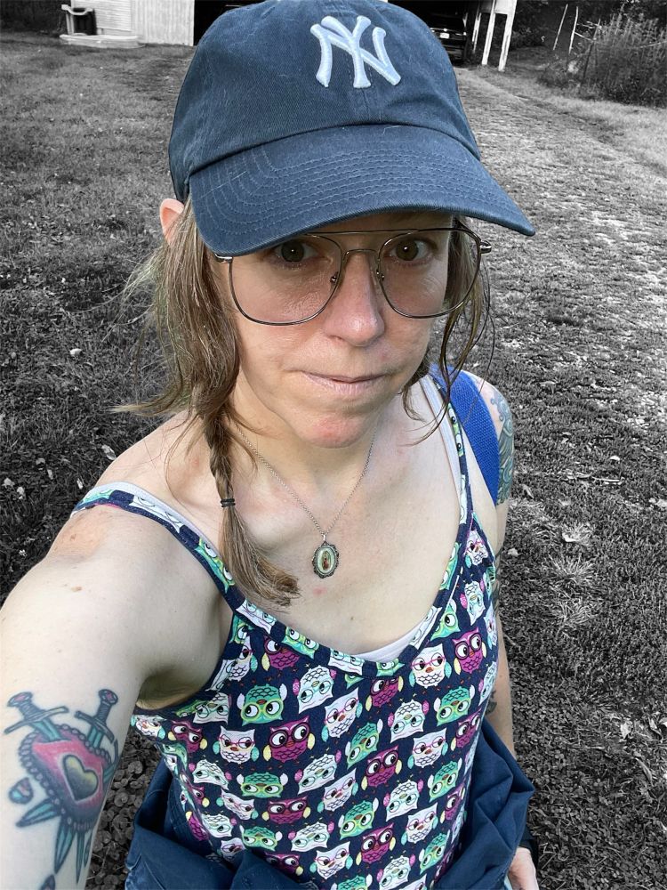 Woman with braids, ball cap, tank top with owl print