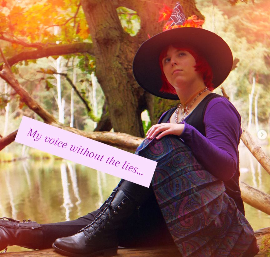 Me in a witch hat and purple outfit, sitting by a lake in a forested area. Text overlay reads: "My voice without the lies...