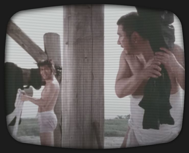 Zatoichi and a young ronin hang their clothes to dry at a structure next to a river.