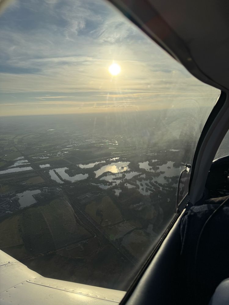 The Sun is blowing the sky over a waterlogged English landscape seen from the air