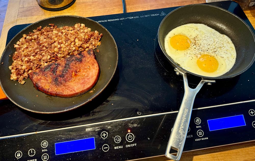 corned beef hash and ham in one pan, fried eggs in another