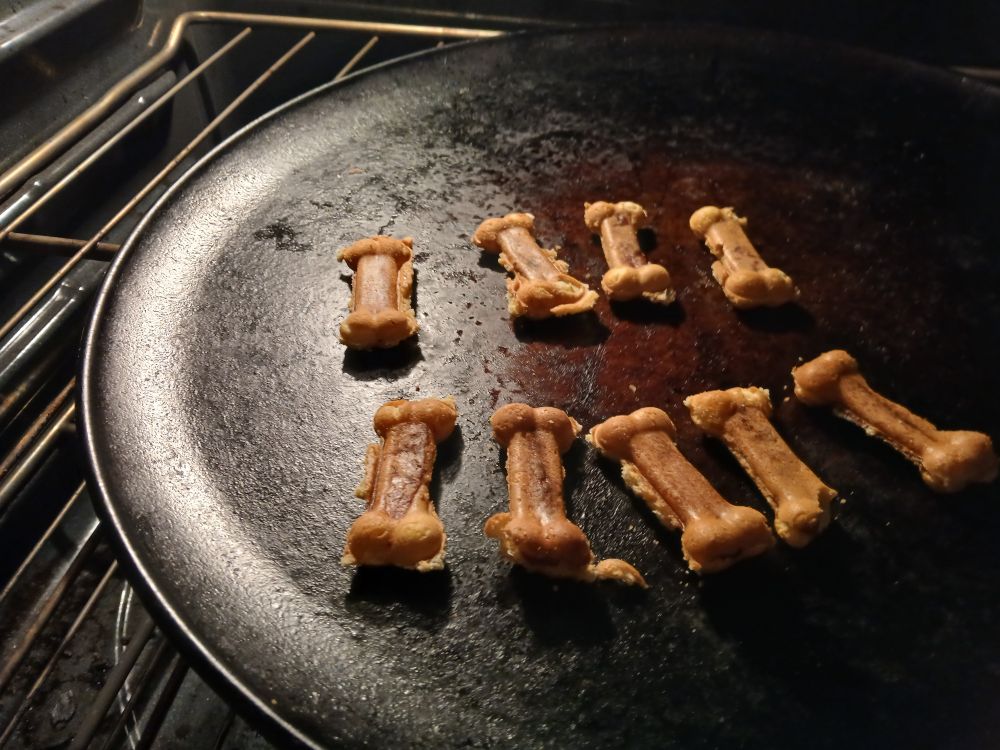 Dogbone shaped mini corndogs in the oven on warm