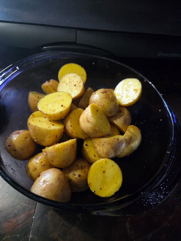 a bowl of seasoned potatoes waiting for the grill