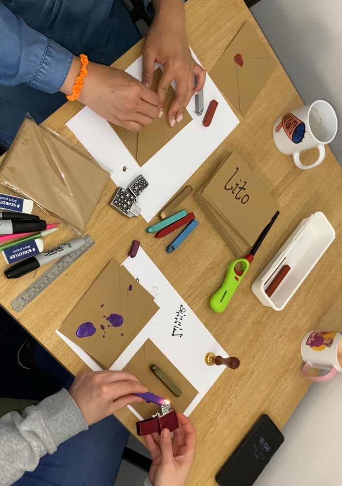 Two Peoples hands creating wax seals for envelopes