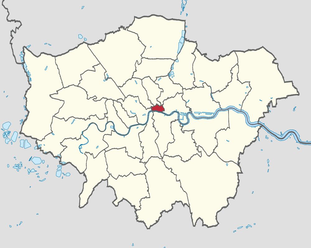 A map of Greater London, England, showing the boundaries of all the London boroughs. The borough of the City of London is highlighted in red at the center of the map, just north of the River Thames. All other boroughs are shown in a light beige color with black borders. The River Thames and other bodies of water are depicted in light blue. The map provides a clear visual distinction of the City of London's central location relative to the other boroughs in Greater London. The map is from https://en.wikipedia.org/wiki/City_of_London
