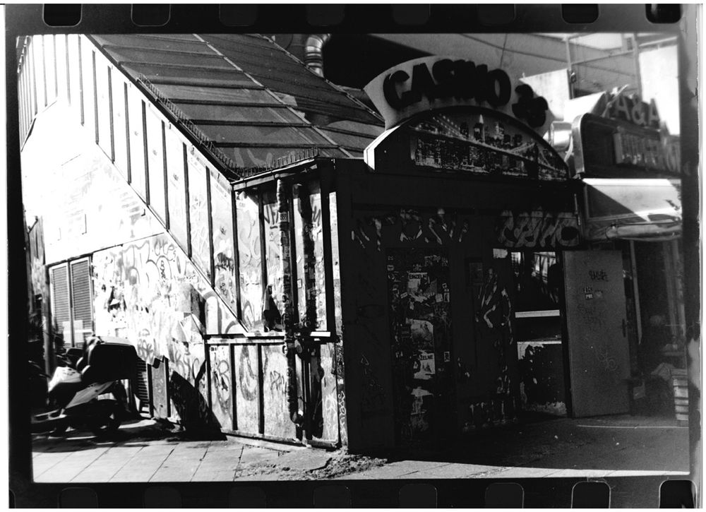 A run down, tagged building with sign “Casino 36” above the open door.
