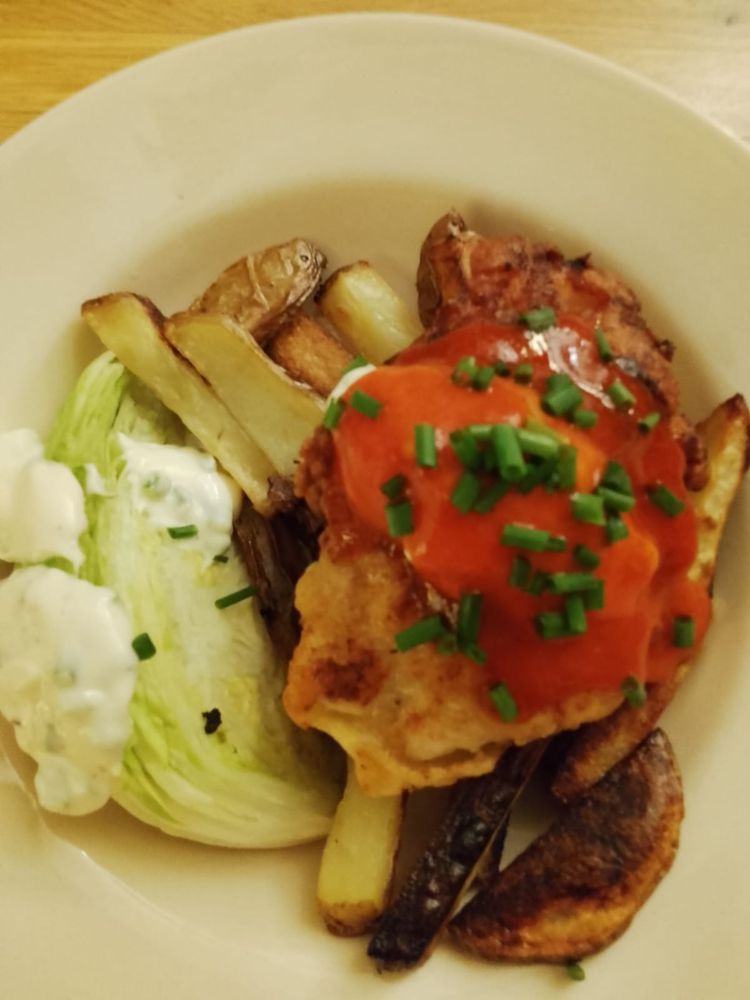 From 9 o'clock on the plate:
Pale green iceberg lettuce wedge with cream/white ranch dressing
Oven baked chips
Brown chicken breast topped with red/orange buffalo sauce and chopped dark green chives