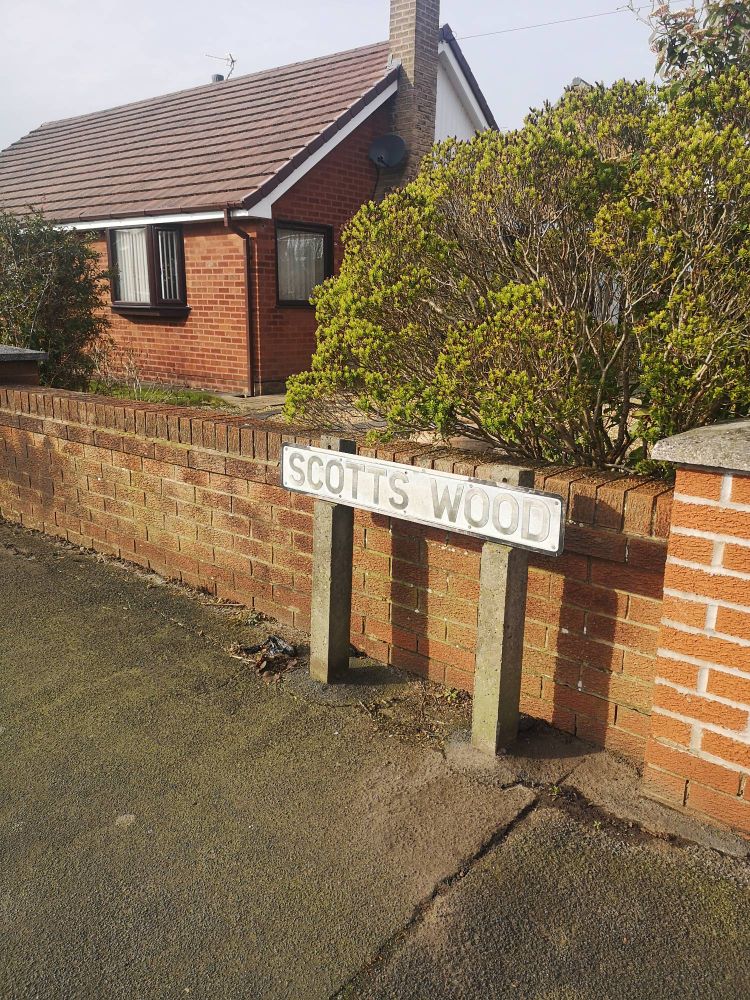 Scott's Wood street sign with dog poo bags being dumped beside it