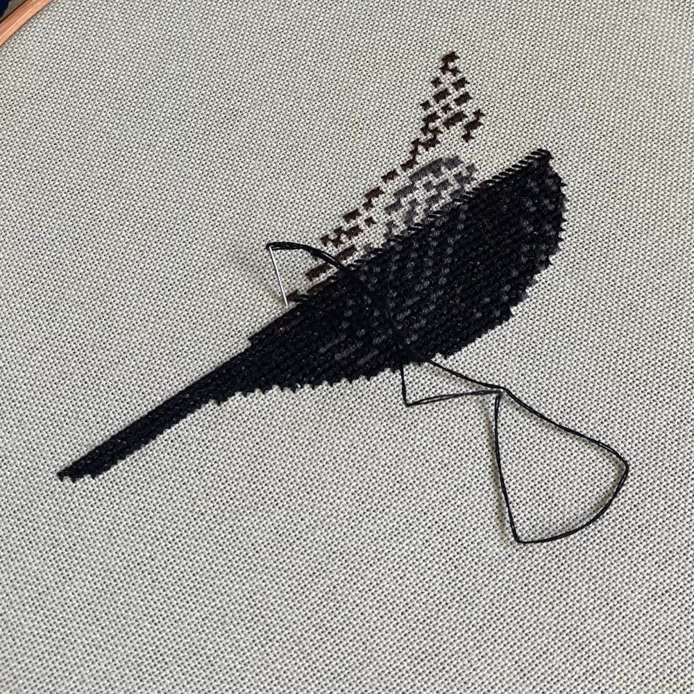 A work in progress picture of my original cross stitch blackbird design, being worked on pale green fabric 