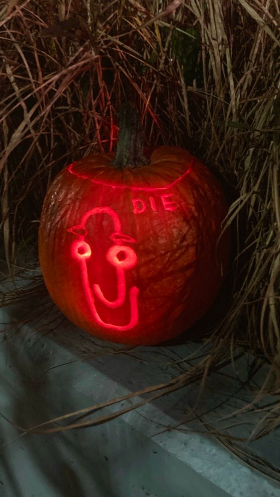 A jack-o’-lantern of clippy, the Microsoft word assistant, with the word “die”.
