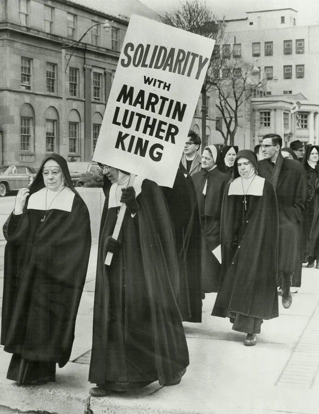 Black and White photo of Nuns (in full, old school floor length habit and veil) and clergy march  two by two in 1965 St Louis