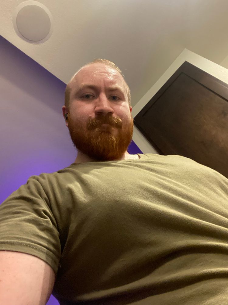 Smoldering bear after his evening workout with a single sore tiddy poking thru a green v-neck