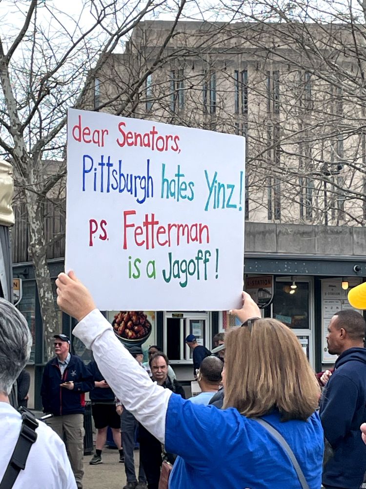 Protest sign says, Dear Senators, Pittsburgh hate yinz. PS Fetterman is a jagoff.